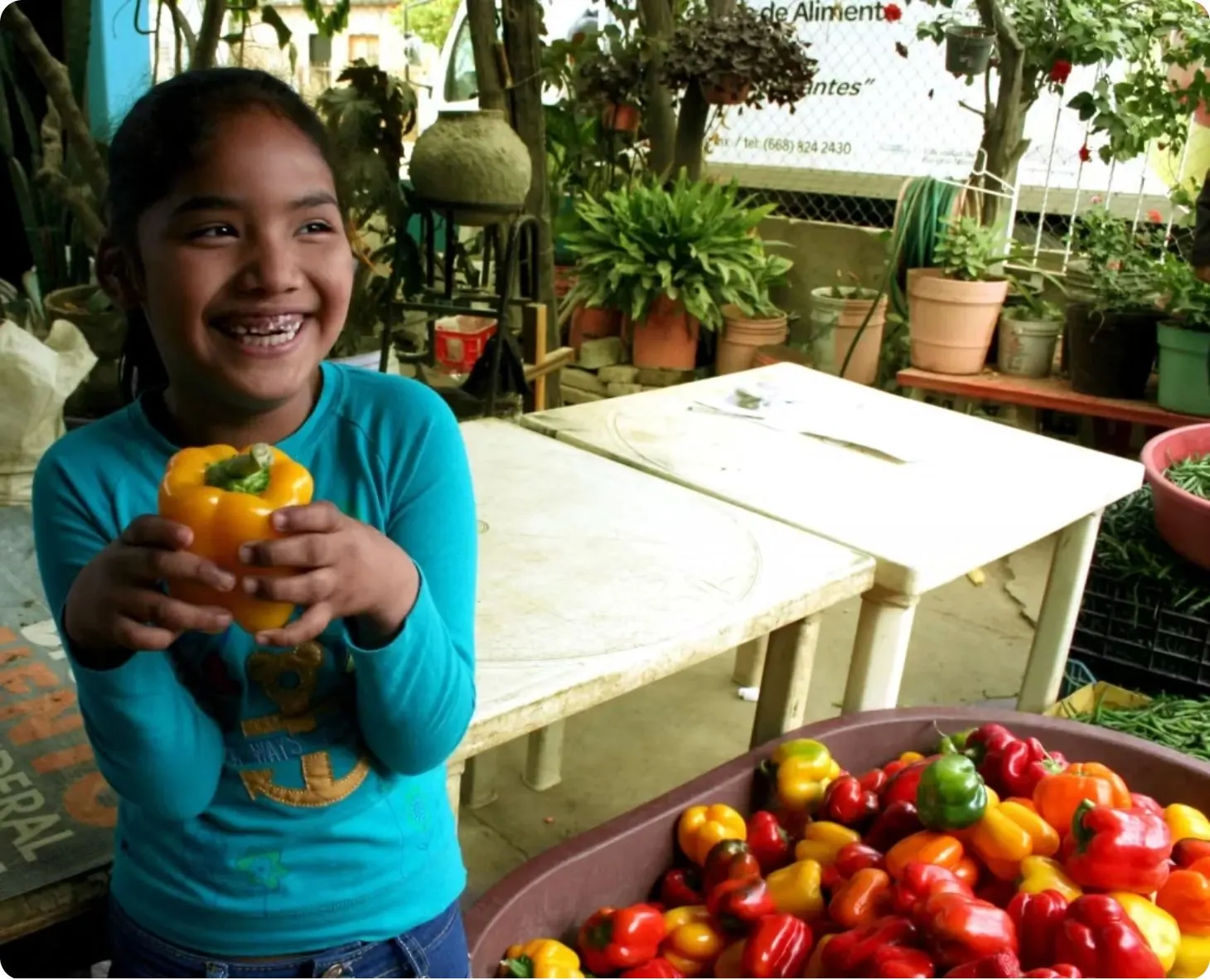 Niña beneficiaria con alimentos frescos